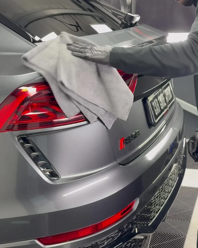 De glascoating op de achterkant van de Audi RS Q8 wordt uitgepoetst met een microvezeldoek